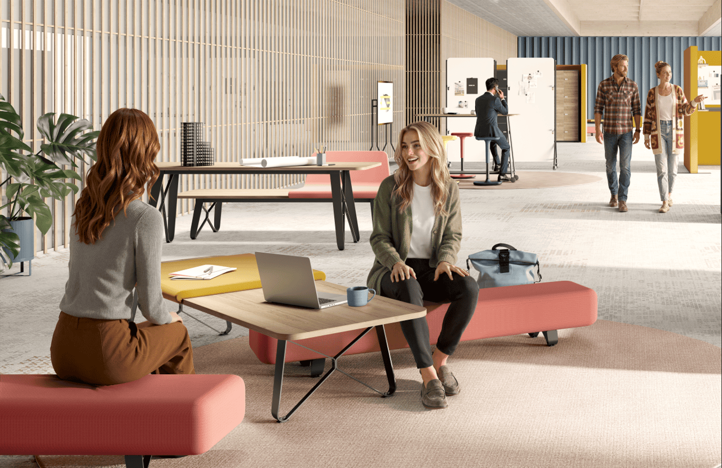 Das Bild zeigt zwei Personen im Gespräche auf stylischen Loungemöbeln in frischen Farben in der Mittelzone eines sehr großen Raumes.
